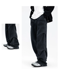 Close-up of baggy black washed denim pants with detailed stitching and tactical seams