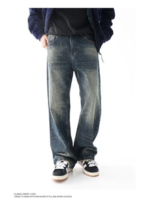 Dettaglio di jeans blu vintage lavati con effetto baffi e orlo consumato
