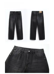 Detailed close-up of washed black denim fabric texture and brown leather waist patch