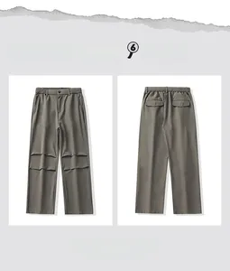 Detail view showing the layered pleats and rear pockets of dark gray casual trousers