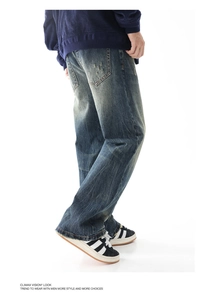 Dettaglio di jeans vintage con baffature sbiadite e orlo sfrangiato per uomo in blu