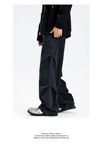Detail of American street style black cargo jeans featuring unique side pleat design