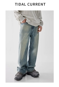 Detail of vintage washed blue wide-leg jeans with whiskered fading and high street style