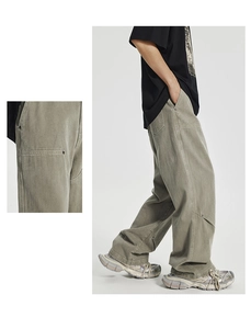 Detailed view of cargo pant side pockets with metallic rivet reinforcements and stitching