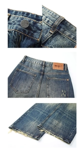 Dettagli dei jeans lavati blu scuro con cinturino, etichetta in pelle e orli sfrangiati