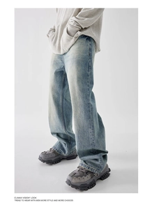 Detail view of light blue washed denim jeans with vintage whiskering and baggy fit