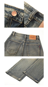 Détails du jean bleu délavé vintage avec bouton en bronze et écusson de marque en cuir