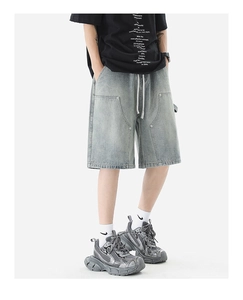Close-up of vintage washed denim carpenter shorts with elastic waist and white drawstring