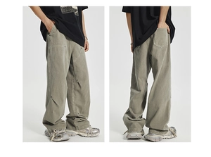 Detail of washed olive green cargo pants featuring reinforced paneling and metal rivets