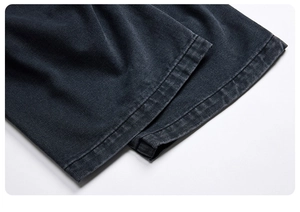Close-up of the double-stitched hem on high-quality washed black denim cargo pants