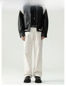 Detailed view of men's cream straight-leg cotton jeans with distressed ink splash design