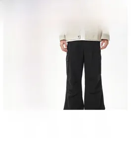 Dettaglio dei pantaloni cargo baggy con grandi tasche laterali e tessuto in twill