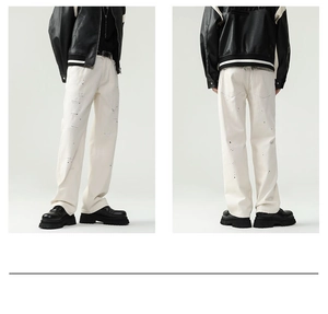 Detail of off-white cotton straight pants with distressed holes and black ink splatter