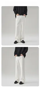 Detailed view of white wide-leg trousers showing straight loose fit and natural drape