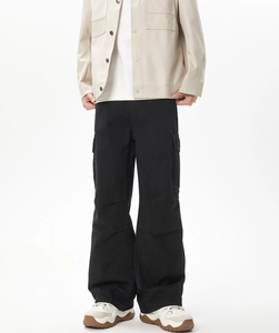 Dettaglio dei pantaloni cargo neri larghi da uomo con tasche laterali e cuciture ginocchio