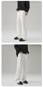 Detail view of white stretch flared denim trousers with clean-fit aesthetic on model