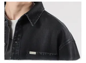 Macro detail of high-density black washed denim fabric and collar on a retro jacket