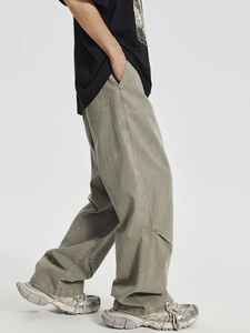 Men's oversized olive green carpenter pants with tactical stitching and metal rivet details
