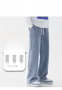 Détail d'un jean large bleu clair avec cordon de serrage en coton et texture denim délavé