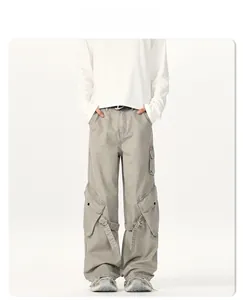 Detail view of light grey cargo pants with multi-pockets and decorative webbing straps