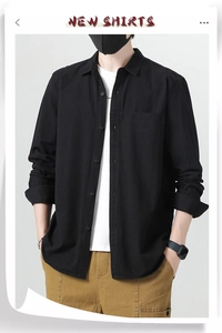 Detail of a men's black long-sleeve cotton shirt featuring a classic collar and single pocket