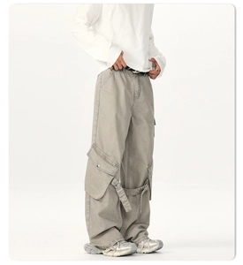 Detailed view of cargo pocket and long ribbons on loose fit green work pants