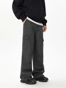 Dettaglio dei pantaloni cargo grigio antracite con multitasche e trama lavata vintage