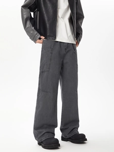 Detail of dark grey cargo pants with side flap pockets and relaxed wide leg fit