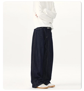 Detail view of dark blue wide-leg denim jeans with contrast yellow stitching
