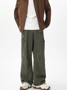 Dettaglio dei pantaloni cargo verde oliva con ampie tasche a patta e gamba dritta larga