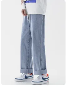 Détail d'un jean bleu clair montrant le cordon de serrage et la texture des poches