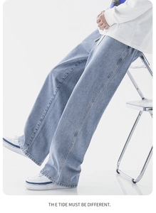 Gros plan sur la texture du denim bleu clair et le cordon blanc à la taille élastique