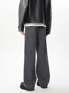 Detail of dark grey wide-leg cargo pants with structural stitching and back pockets