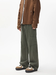 Detail of vintage workwear jacket and cargo pants showing fabric texture and pocket design