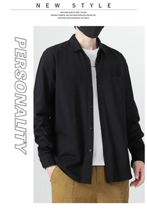 Detail view of black cotton long sleeve shirt showing chest pocket and button-down collar
