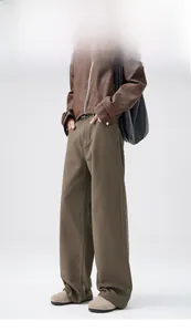 Detail view of men's wide-leg brown denim pants with straight-cut design and premium fabric