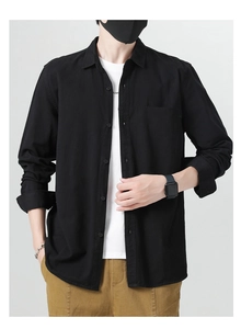 Detail view of men's black cotton casual shirt featuring a front pocket and button closure