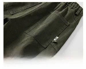 Close-up of military green heavy cotton trousers showing elastic waist and back pocket detail