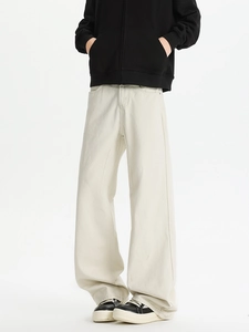 Detail of cream white wide-leg trousers showing drape and thick canvas texture on model