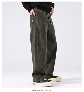 Detail of army green heavy-duty carpenter pants with drawstring waist and loose fit silhouette