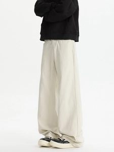 Detailed side view of off-white wide-leg flare trousers with cleanfit aesthetic and heavy drape