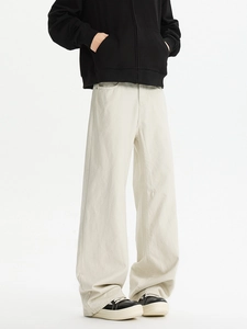 Detail view of cream-colored wide-leg trousers with premium heavy cotton texture and side pockets