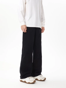 Detail view of black wide-leg cargo pants with knee paneling and washed cotton texture