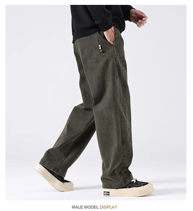 Detail view of olive green cargo pants showing the wide leg fit and side utility pocket
