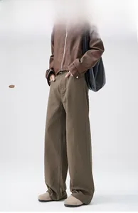 Detail view of coffee brown wide-leg twill trousers showing rich fabric texture and drape