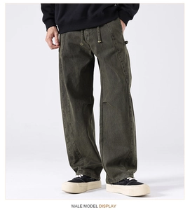 Detail of loose-fit olive green cargo pants with drawstring waist and vintage texture