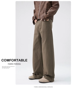 Detail of loose-fit olive green wide-leg trousers paired with a brown zip-up jacket