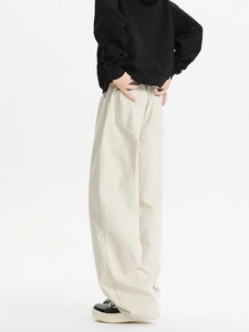 Detail view of beige wide-leg trousers featuring structured fabric and back pocket design