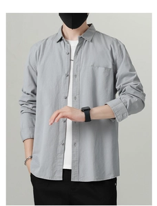 Close-up of light grey cotton shirt featuring a classic lapel and functional chest pocket