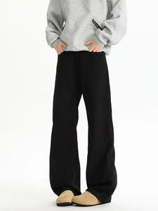 Detailed view of black wide-leg trousers featuring a loose fit and elegant drape